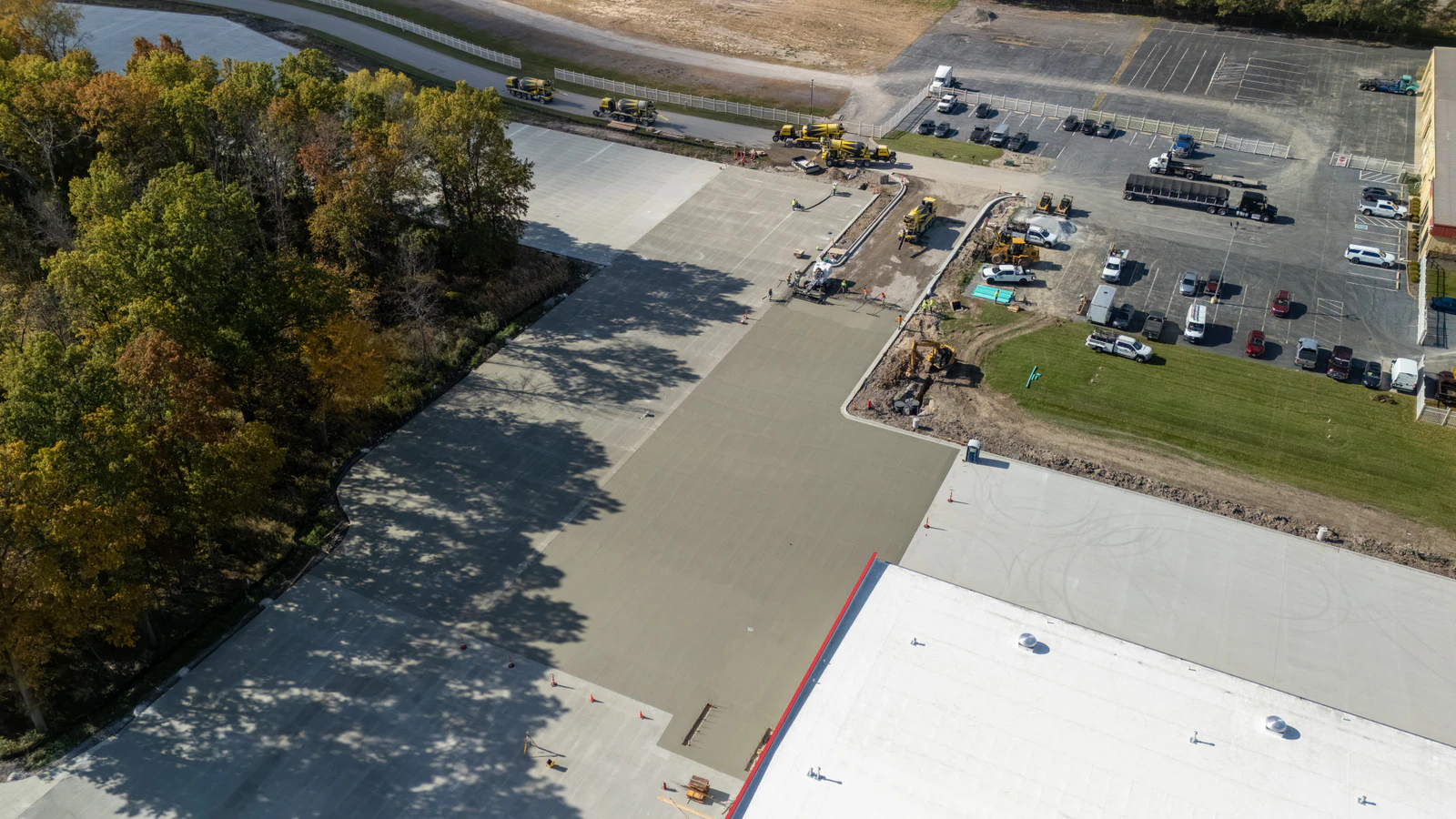 Aerial view of a new concrete dealership lot under construction at Rihm Kenworth, with forms and fresh slabs in place