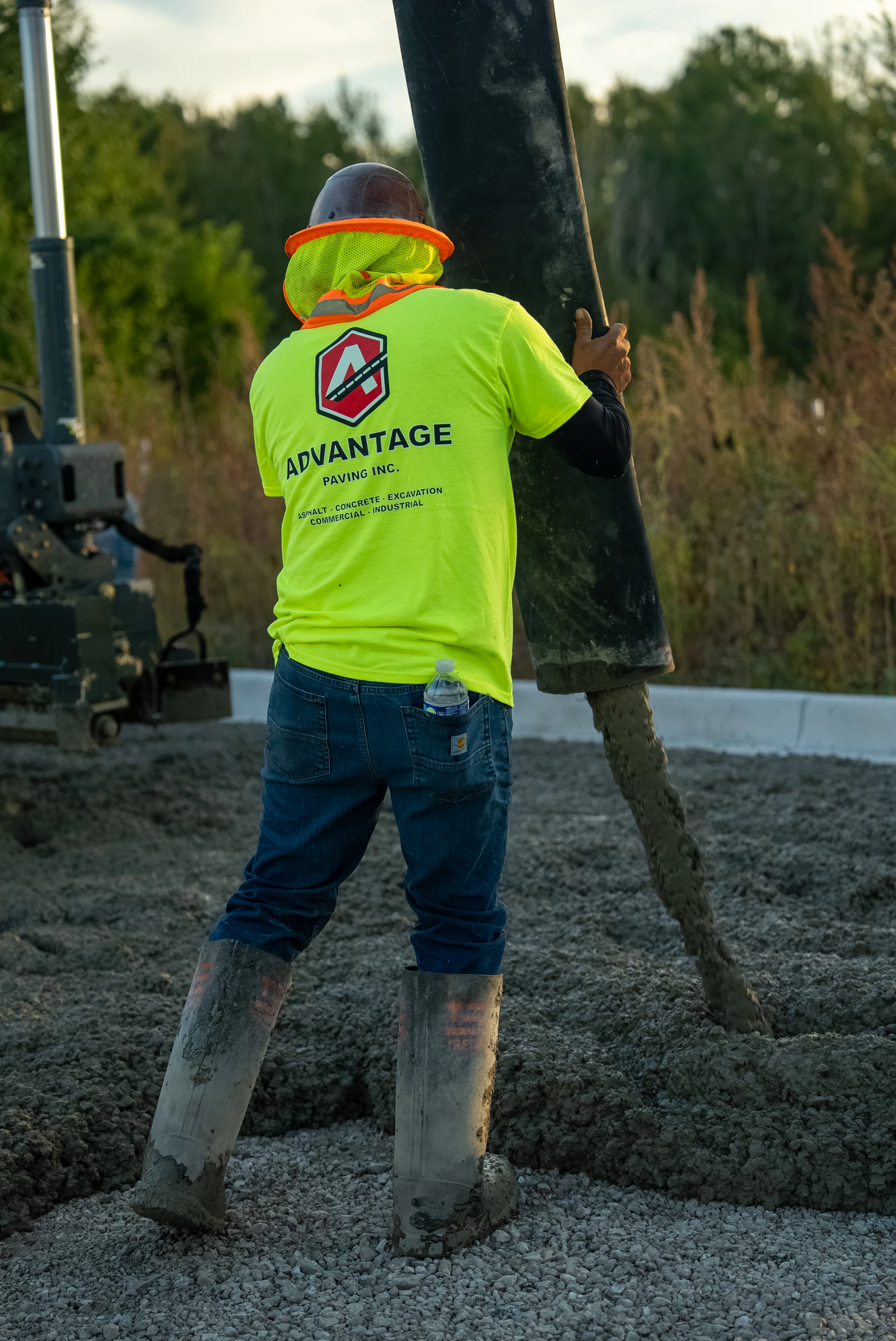Advantage Paving crew member in a high-visibility shirt working a concrete pour on site
